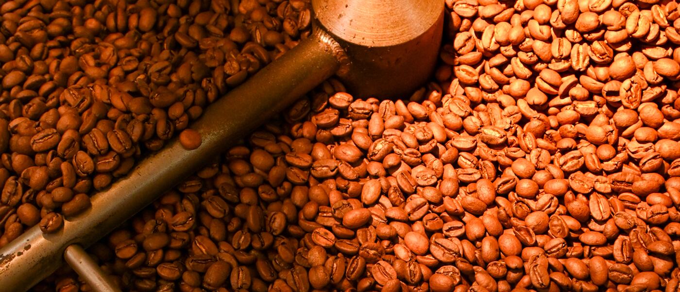 Café recién tostado removiéndose en la bandeja de enfriado del tostador de Selenia